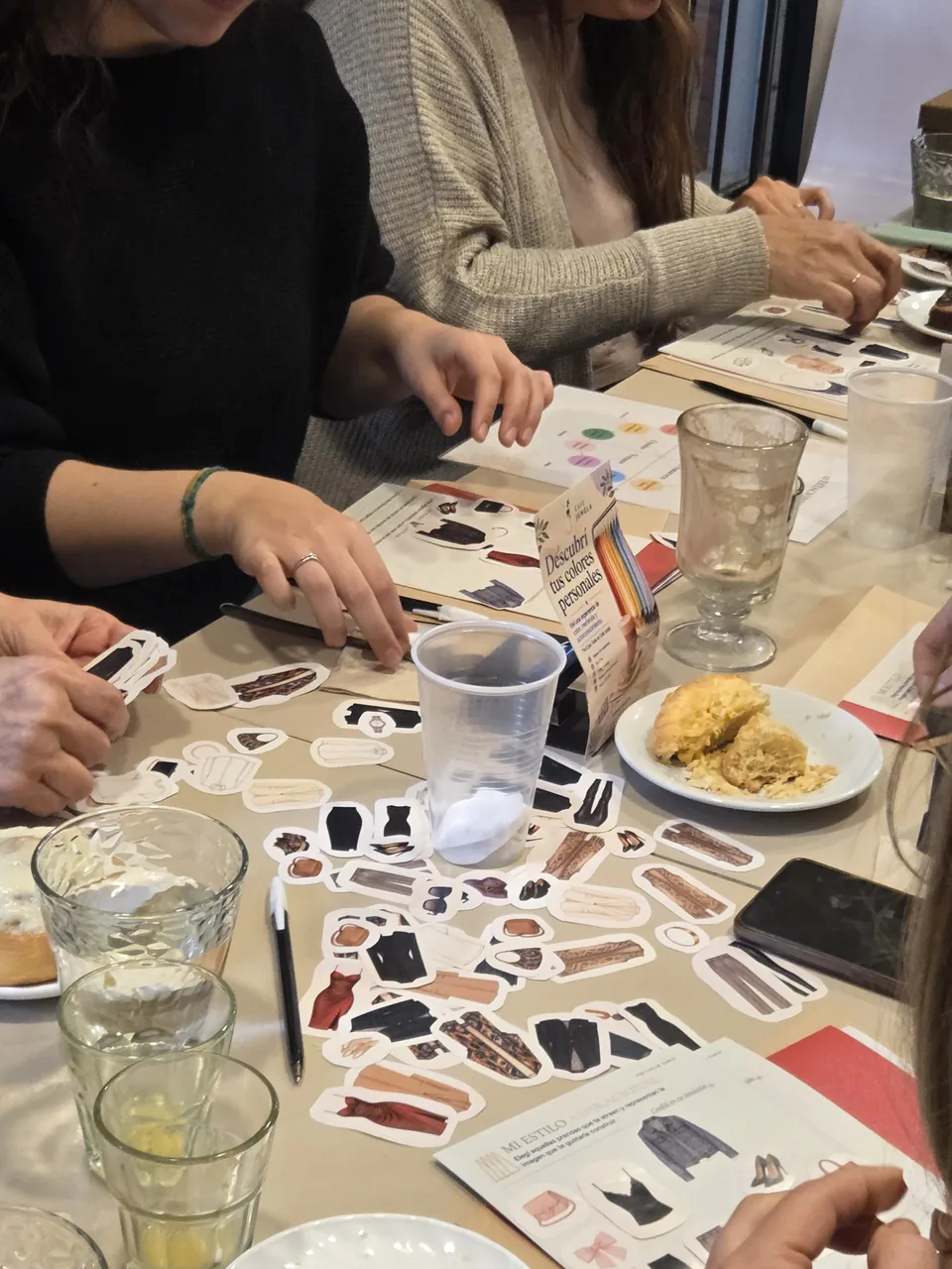 Participantes trabajan con telas y muestras de color en una mesa