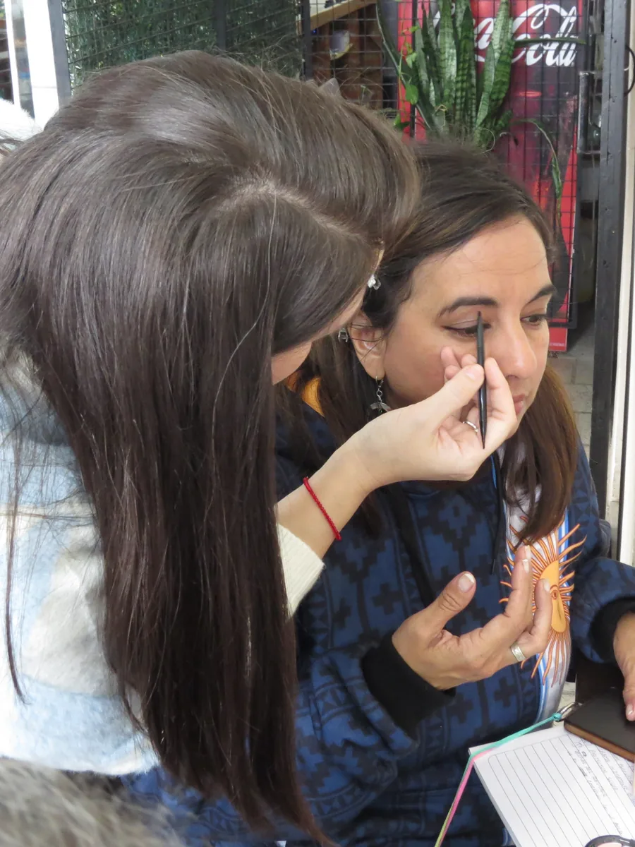 Una participante muestra una técnica de maquillaje a otra durante un taller